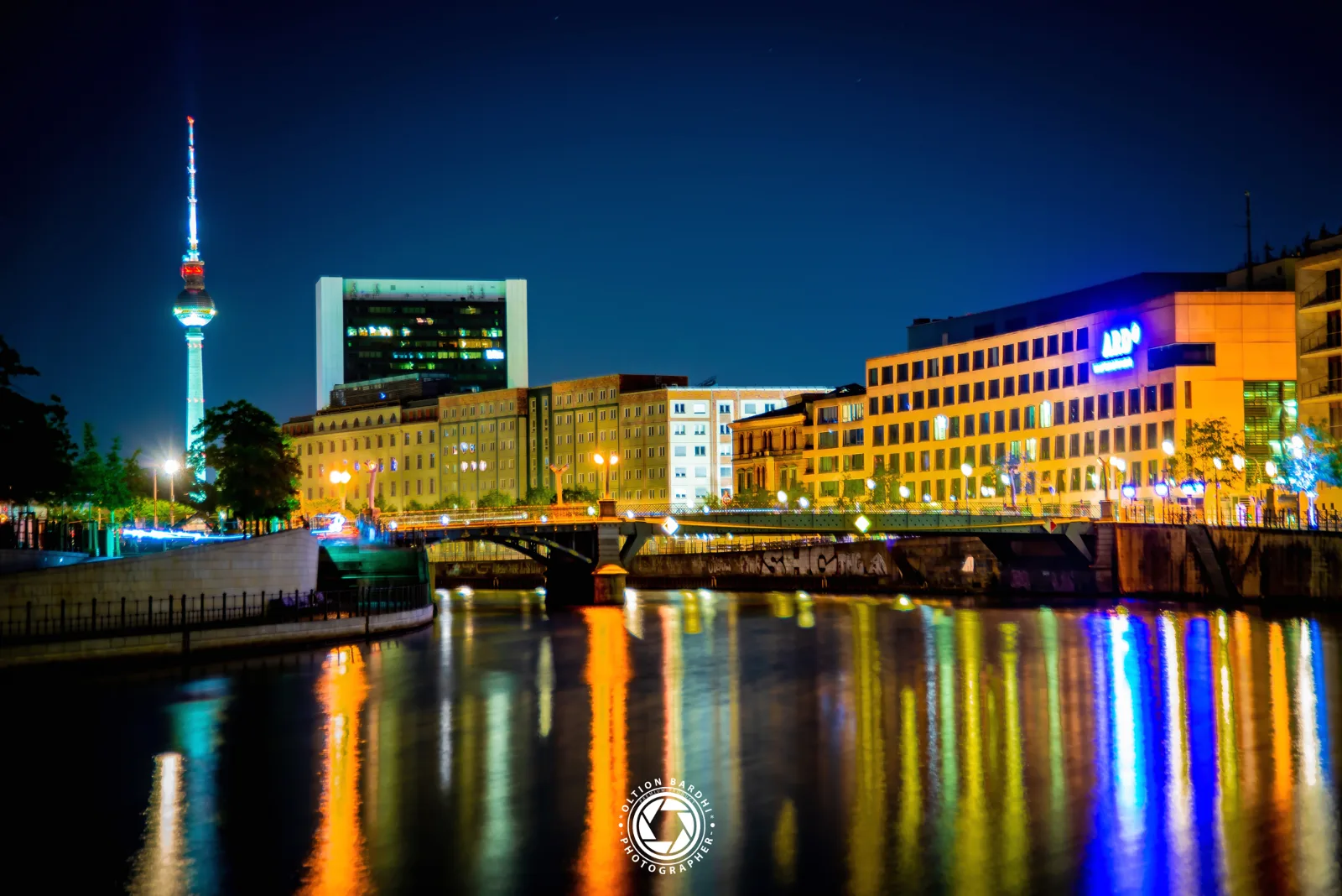 Berliner Skyline mit Fernsehturm, gespiegelt in der Spree bei Nacht