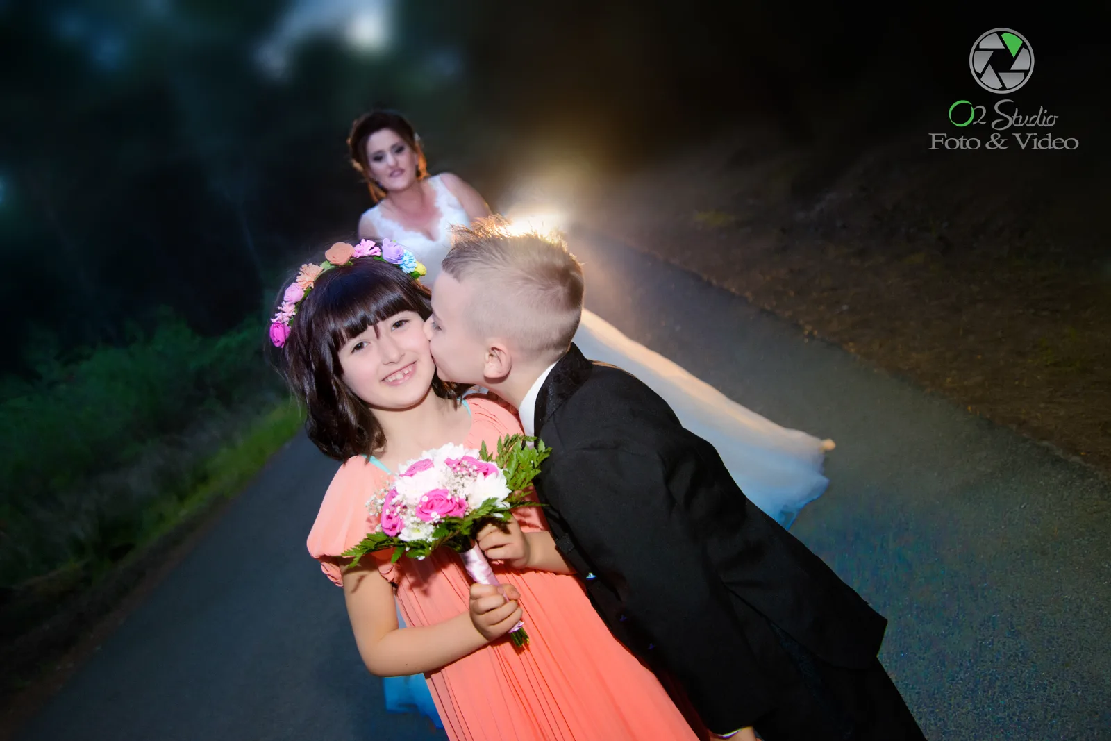 Blumenkinder bei einer Hochzeit, die Braut im Hintergrund