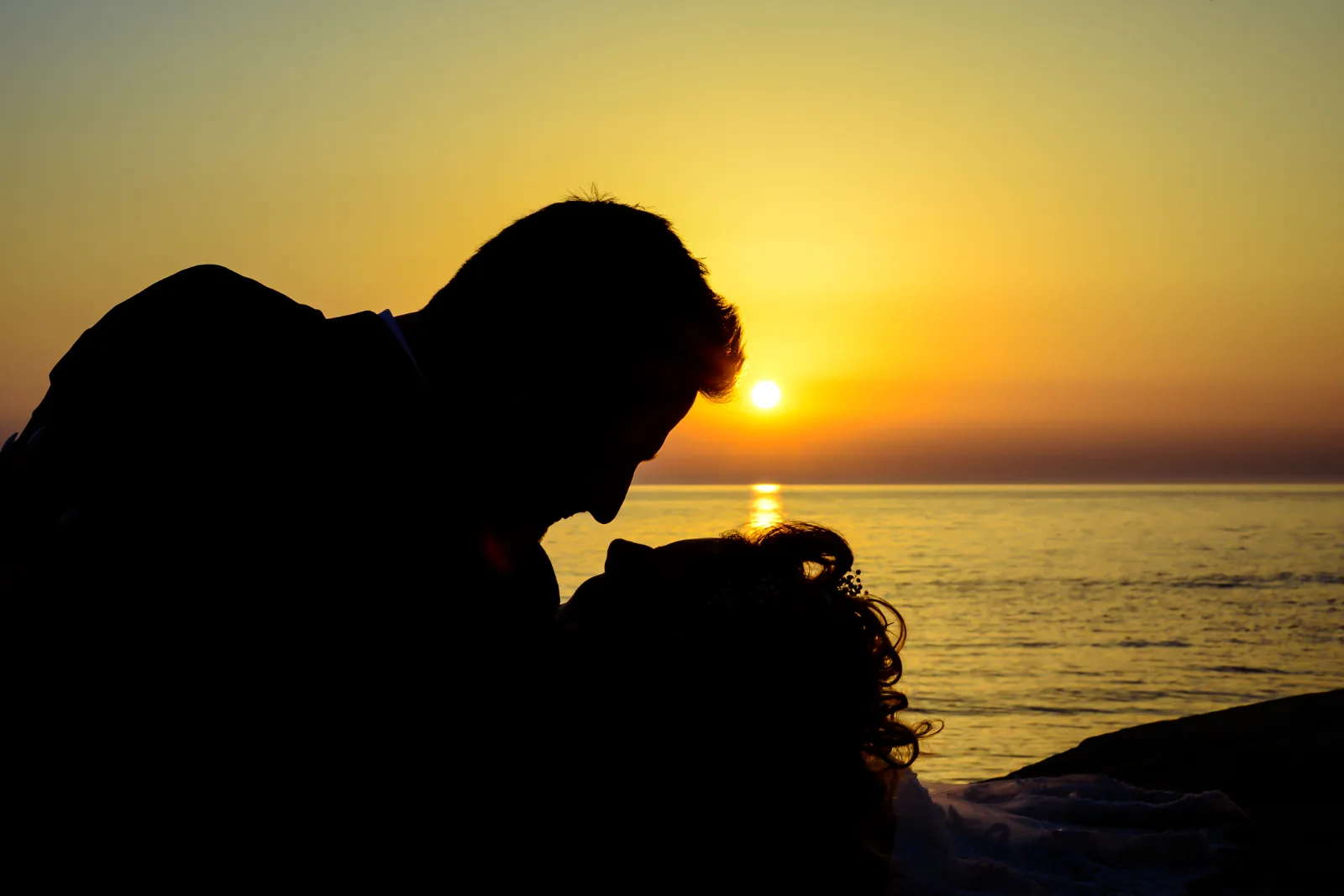 Silhouette eines Paares im Sonnenuntergang am Meer